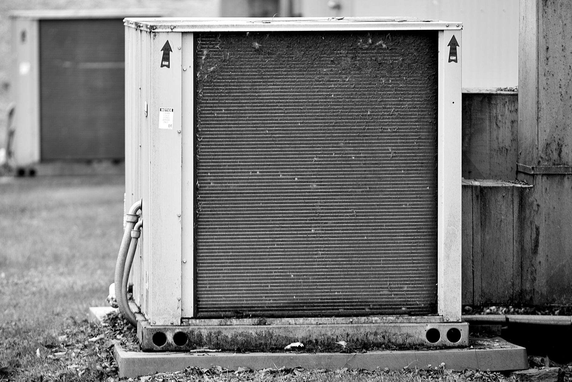 Outdoor air conditioning condenser unit beside a home